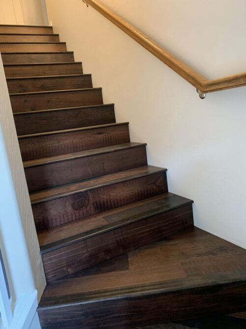 Second picture of Armstrong Woodland Relics Storied Farmstead, an engineered hardwood flooring, installed in stairs. It combines oak, hickory and birch into a reclaimed, weathered, random wood board flooring look, on closeout sale at Colonial Decorators in Grants Pass, Oregon.